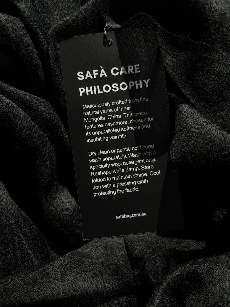 Black cashmere fabric with a Safà Boutique care tag